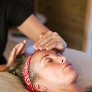 A woman enjoying a peaceful reiki session in a cozy spa setting for ultimate relaxation.